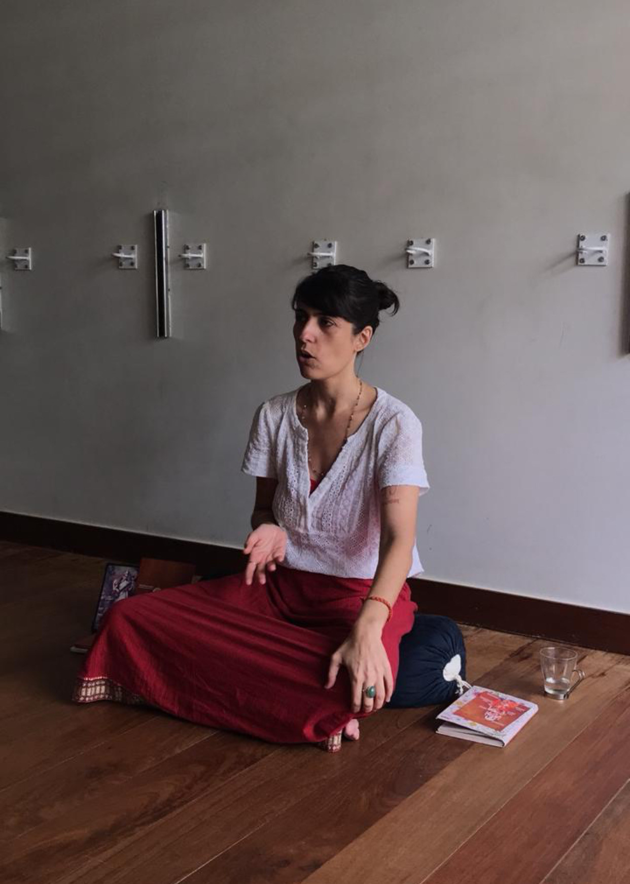 Marina sentada no chão de uma sala, durante uma aula
